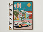 Framed Mediterranean Village artwork with a vintage car. The artwork features coastal teal and coral decor. This art print has a brown frame. You can see all of the frame options available on the side. Perfect for adding a touch of tropical style to your home.