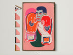 Framed retro pop art boxing legend canvas print. It features a boxer with orange gloves and a pink background. Various frame options are displayed. This artwork will add athletic inspiration to any space.