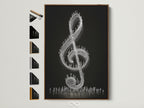 A treble clef artwork is displayed in a brown frame. The artwork features a black background. Tiny figures make up the musical symbol. Explore frame options for your music wall art today. Perfect for music teachers and music lovers.