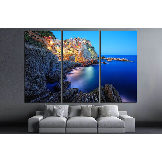 Manarola Cinque Terre Canvas Print - Italian Riviera Wall ArtThis multi-panel canvas print captures the picturesque village of Manarola, part of the Cinque Terre on the Italian Riviera. The vibrant houses perched atop the rugged cliffside, overlooking the