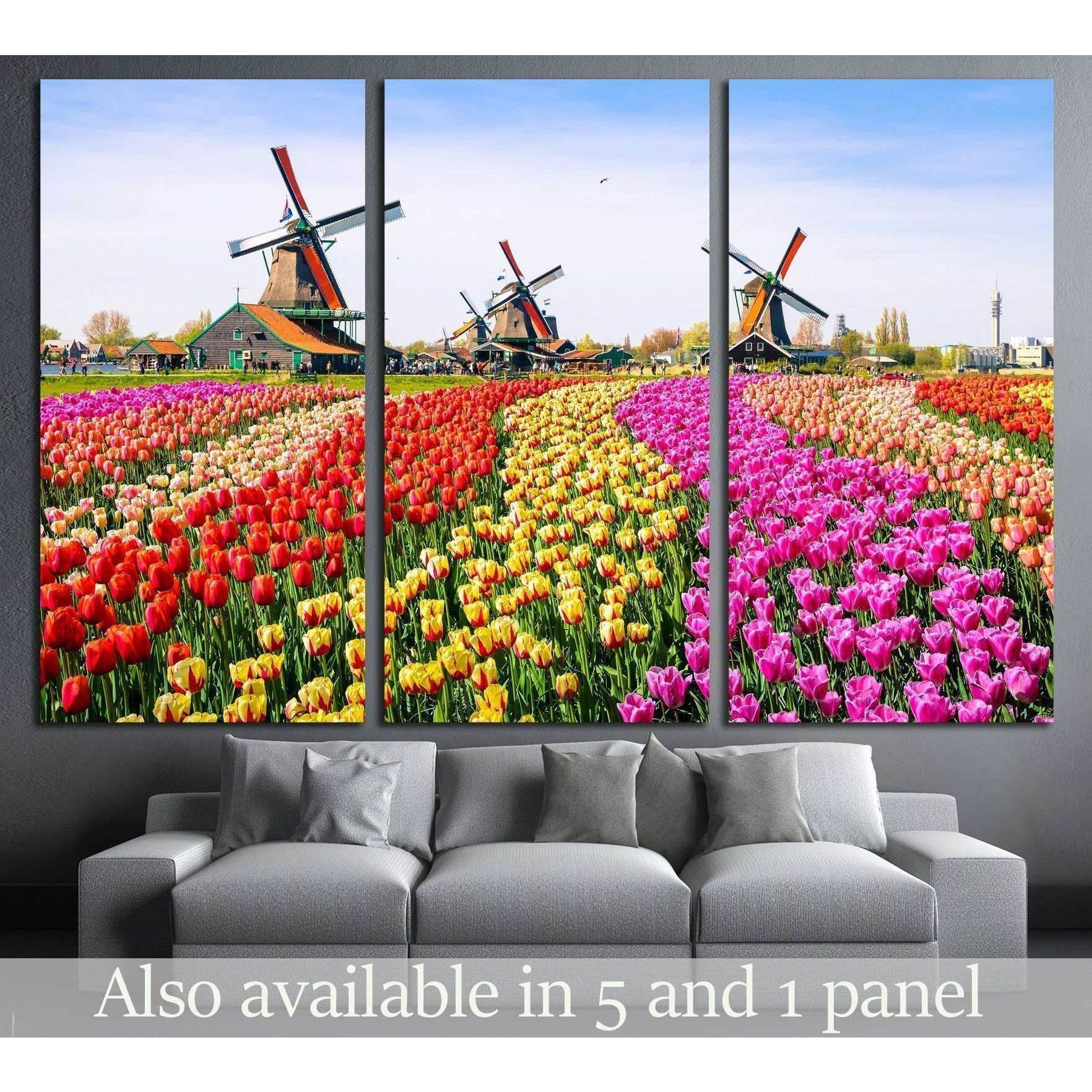 Zaanse Schans Windmills and Tulip Fields Canvas for Vibrant DecorThis canvas print vividly portrays the charming Zaanse Schans with its iconic windmills standing tall above a vibrant field of tulips in the Netherlands. The array of colors and the historic