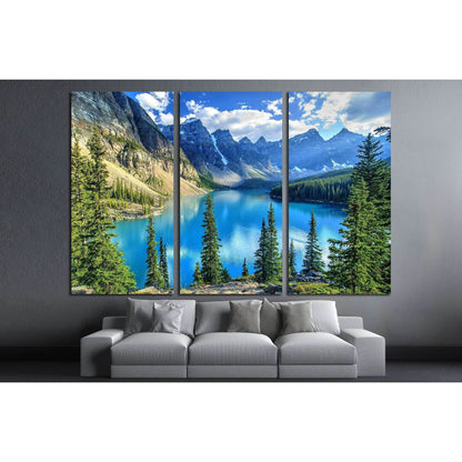 Moraine Lake and Wenkchemna Peaks Canvas Print - Majestic Landscape Wall ArtThis canvas print captures the stunning Wenkchemna Peaks reflected on the serene Moraine Lake, with its vibrant turquoise waters surrounded by verdant evergreens. The majestic mou